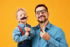 Pai e filho brincando com bigode do Kit festa dia dos pais